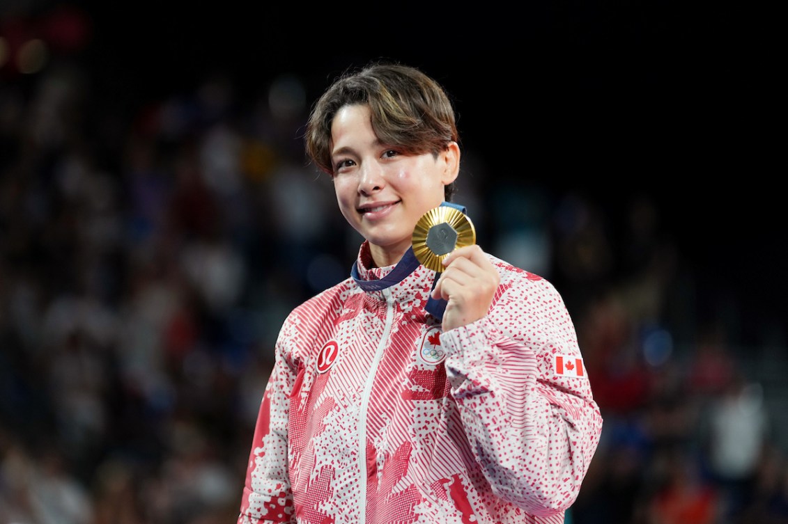 Christa Deguchi holds up her gold medal 