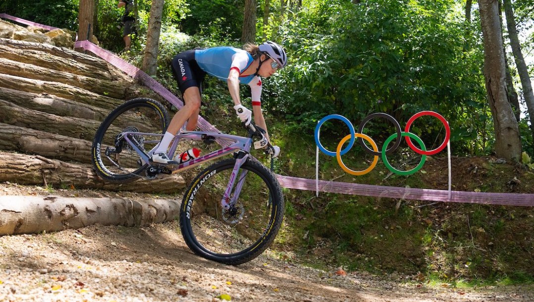 Isabella Holmgren rides down stairs past the Olympic rings on a mountain bike course