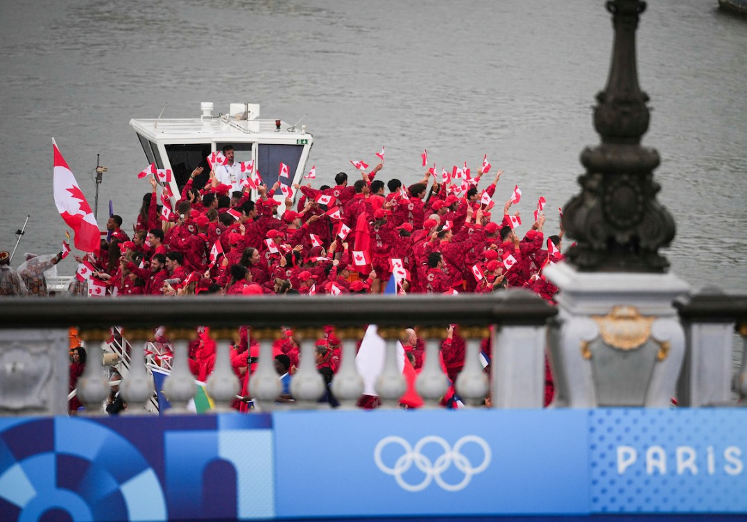 Team Canada waves to the crowd while on a boat on the River Seine