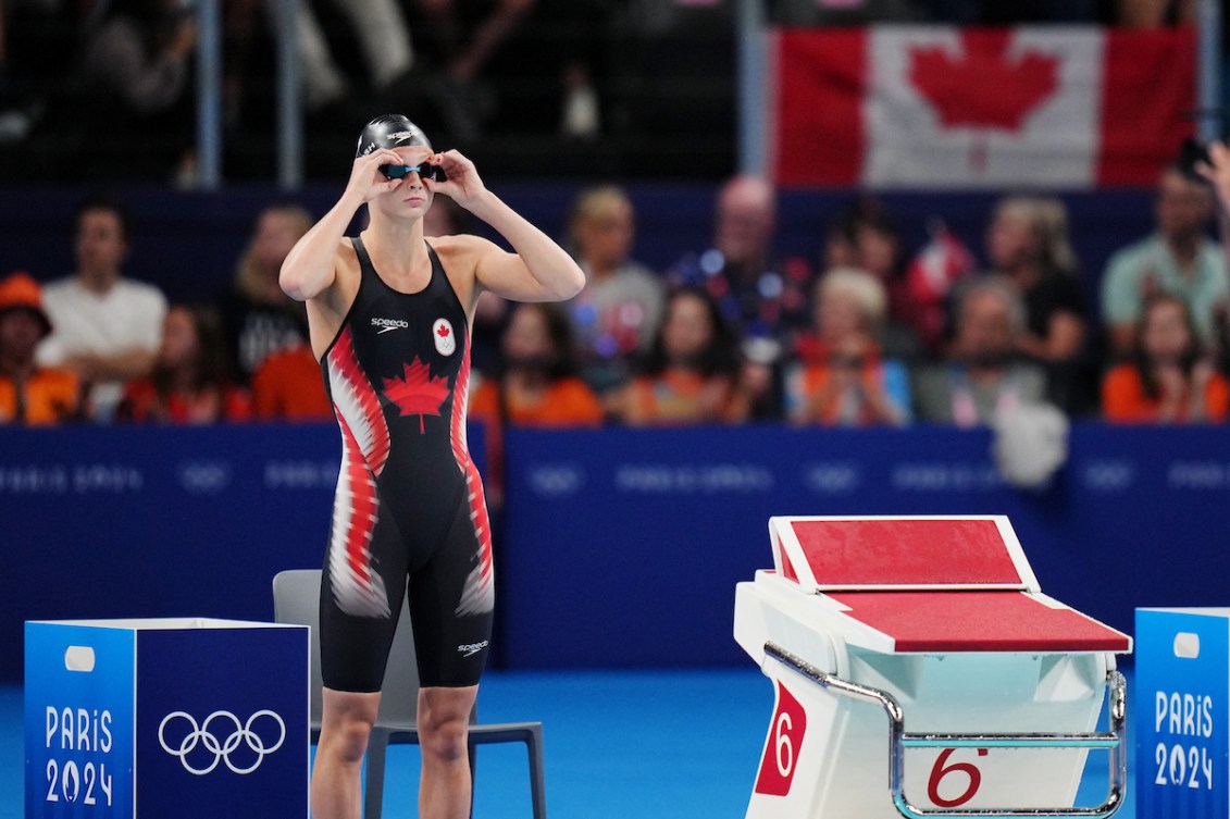 Summer McIntosh standing beside the starting block before a swim race.