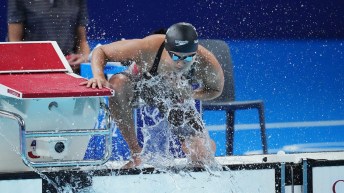 Maggie Mac Neil splashes herself with water on the pool deck