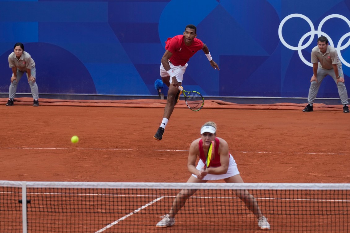 Felix Auger-Aliassime hits a serve during the bronze medal match.