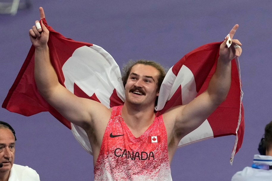 Ethan Katzberg celebrates with a Canadian flag.