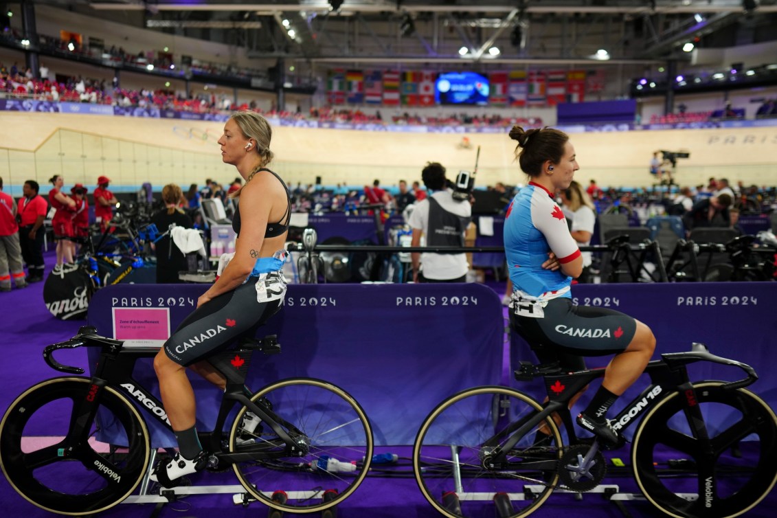 Kelsey Mitchell and Lauriane Genest prepare for a track cycling race.