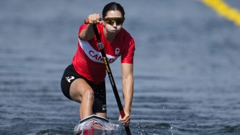 Katie Vincent paddles towards the camera in a canoe