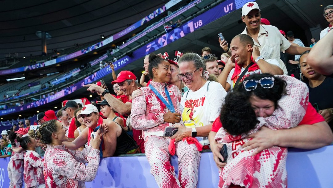 Canadian women's rugby players celebrate in the stands with their family