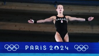 Caeli McKay prepares to jump off a diving board