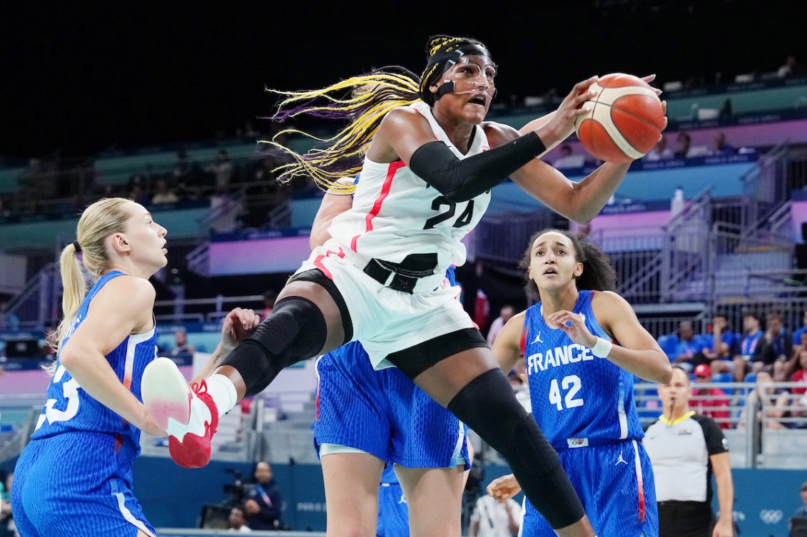 Aaliyah Edwards grabs a ball with hair flying 