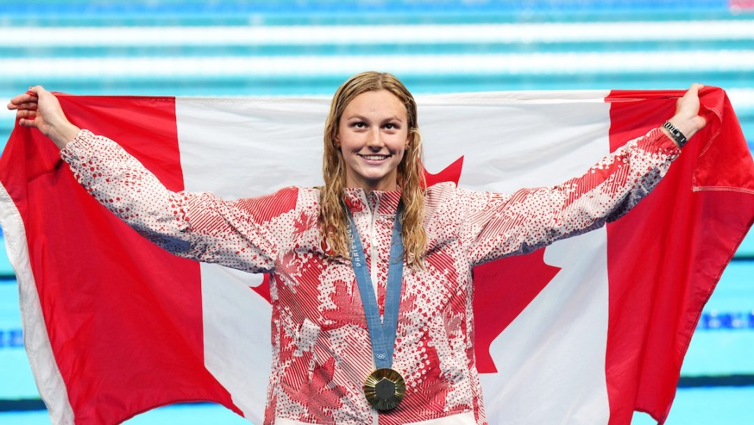 Summer McIntosh with her gold medal and a Canadian flag around her