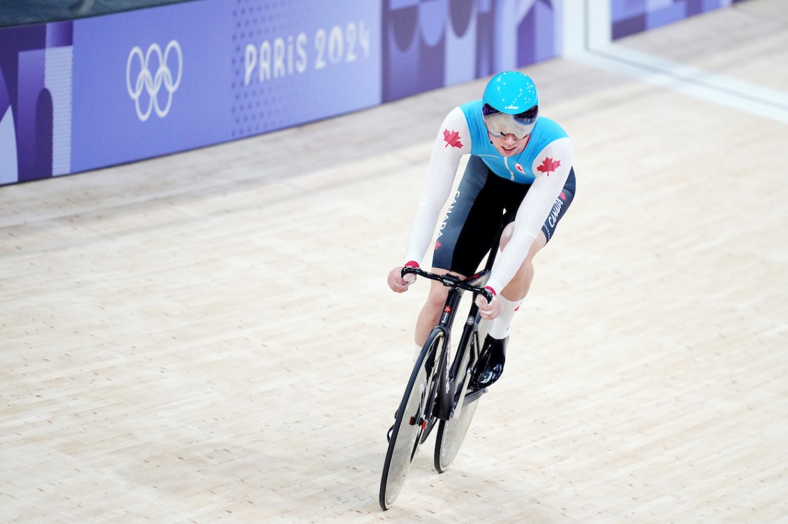 A track cyclist wears a blue singlet