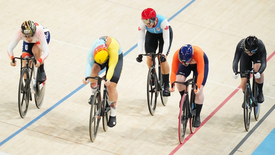 Five track cyclists race on a velodrome