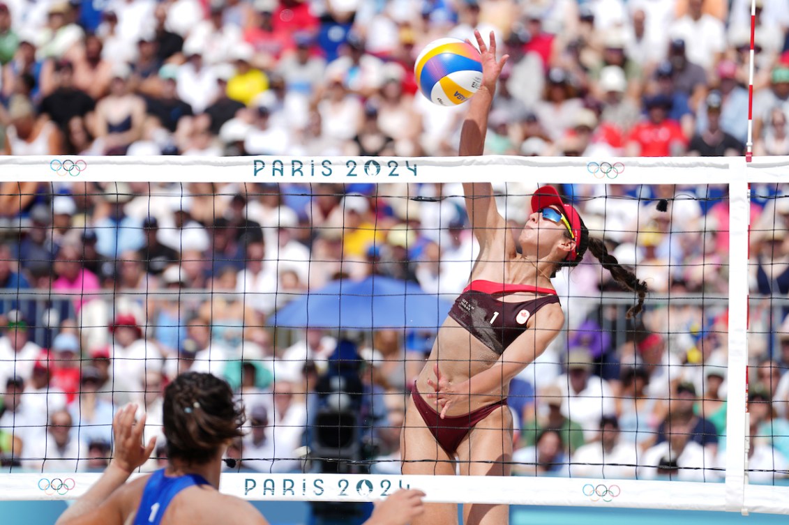 Melissa Humana-Paredes jumps above the net with packed crowds in the background