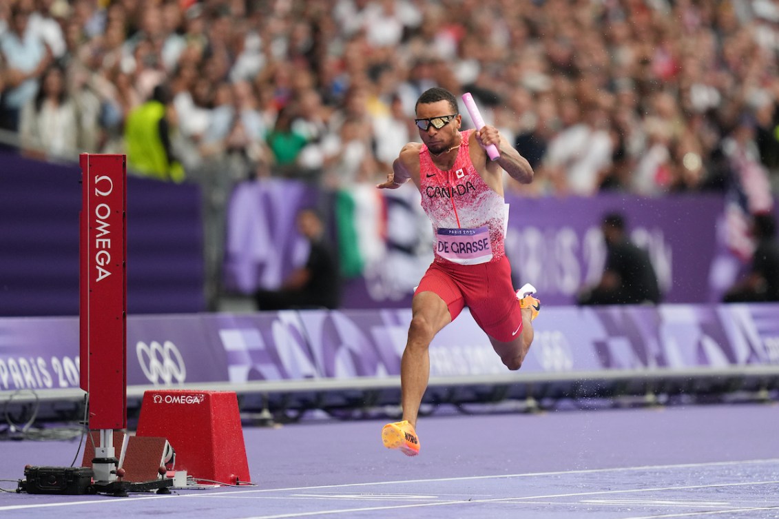 Andre De Grasse crosses the finish line in the men's 4x100m relay final.