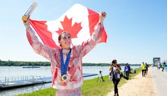 Katie Vincent carries a Canadian flag over her shoulders