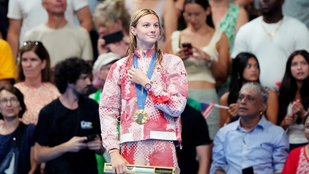 Summer McIntosh stands on the podium with gold medal