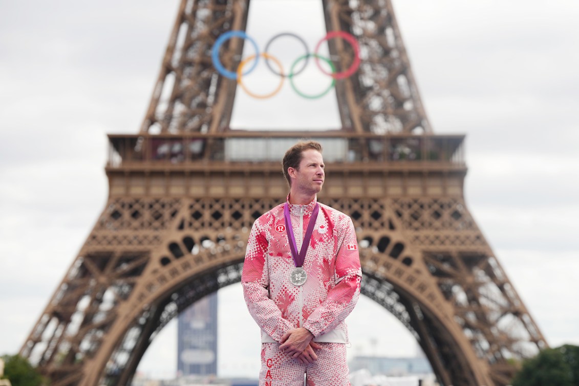 Derek Drouin stands with his silver medal in front of the Eiffel Tower