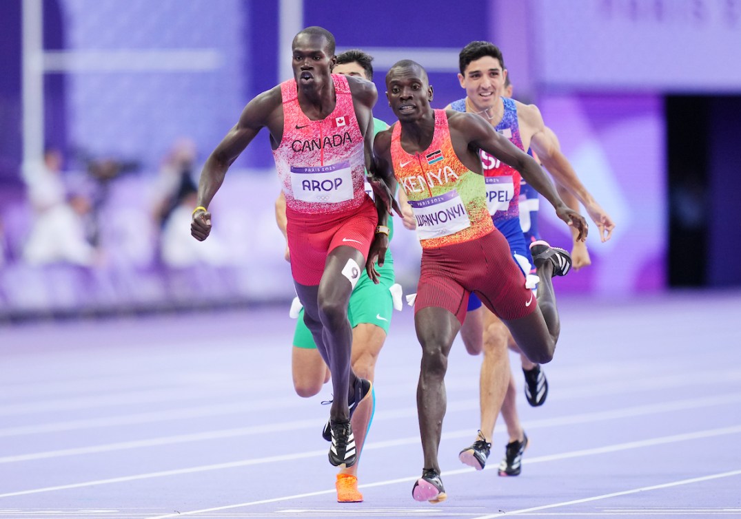 Marco Arop tries to sprint past a Kenyan runner