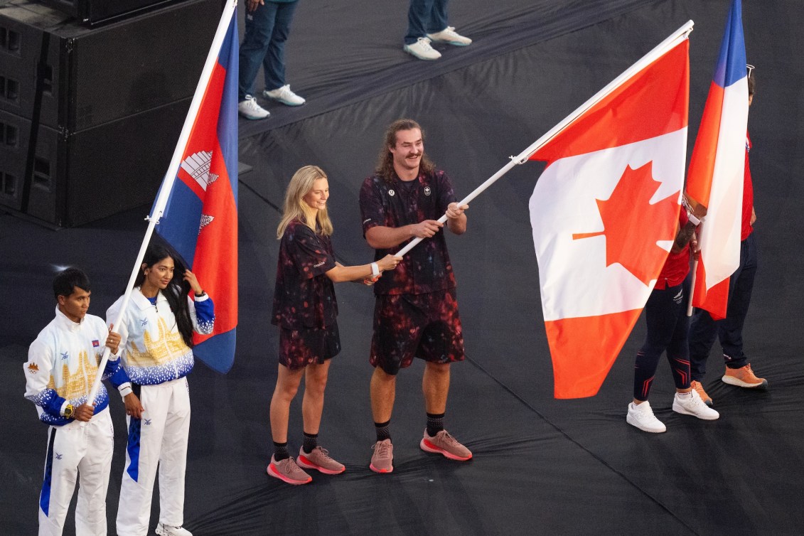 Team Canada's flag bearers Evan Katzberg and Summer McIntosh walk into the Stade de France for the closing ceremony of the 2024 Paris Olympic Games in France.