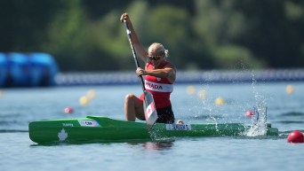 Sophia Jensen paddles a green canoe