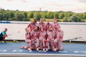 The Canadian women's eight pose with their silver medals while wearing red and white track suits