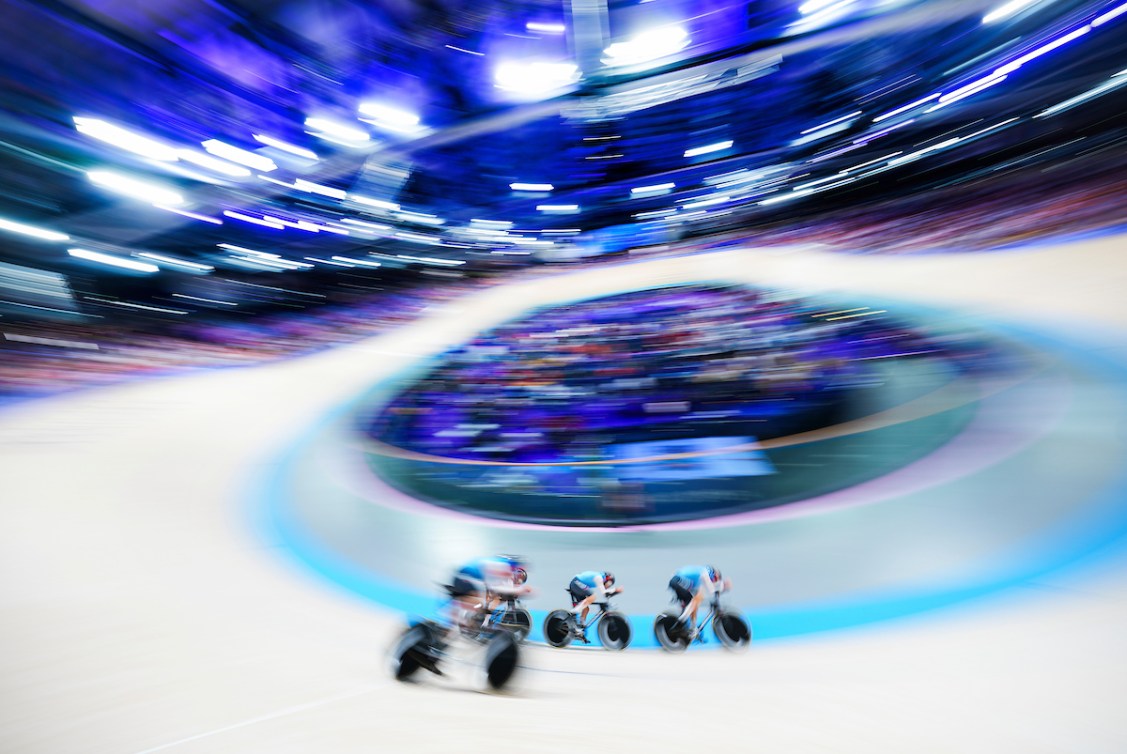 A blurred shot of the velodrome with three riders