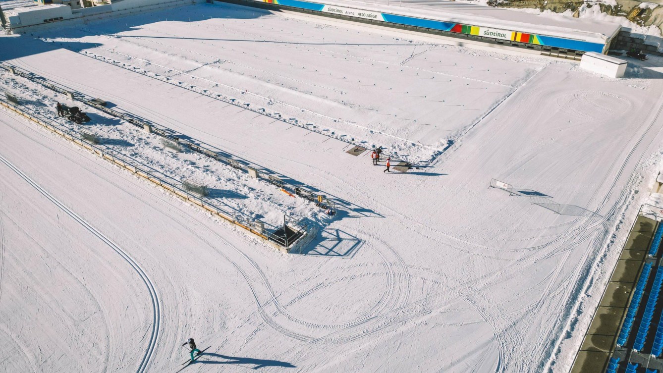 Aerial shot of the Anterselva Biathlon Arena, featuring one skier on the course