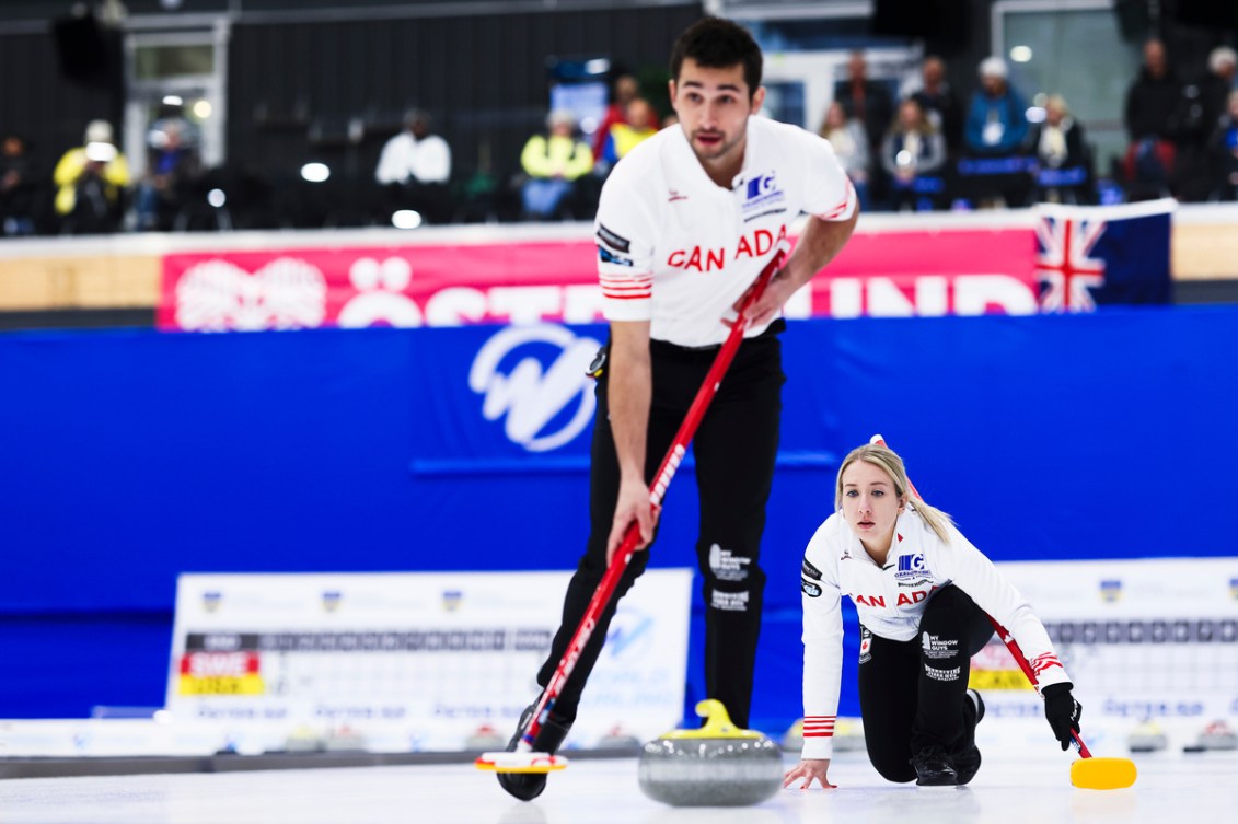 Kadriana Lott throws a yellow stone that Colton Lott prepares to sweep 