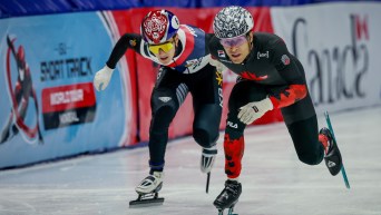 William Dandjinou sprints ahead of a competitor while wearing a black and red speed suit