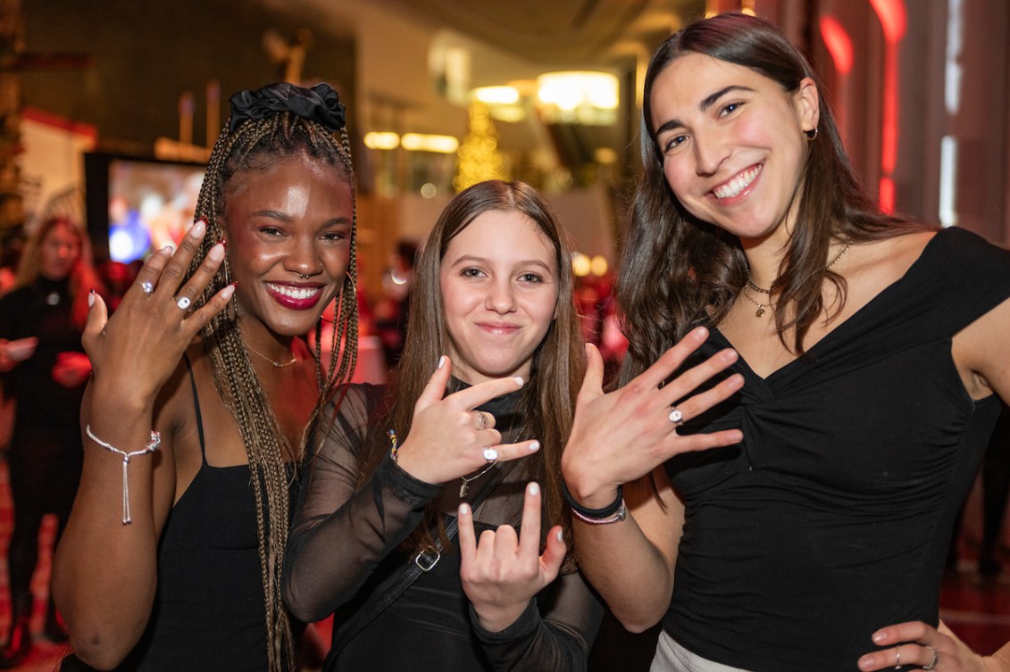 Three athletes show off their Teck Olympic rings on their fingers