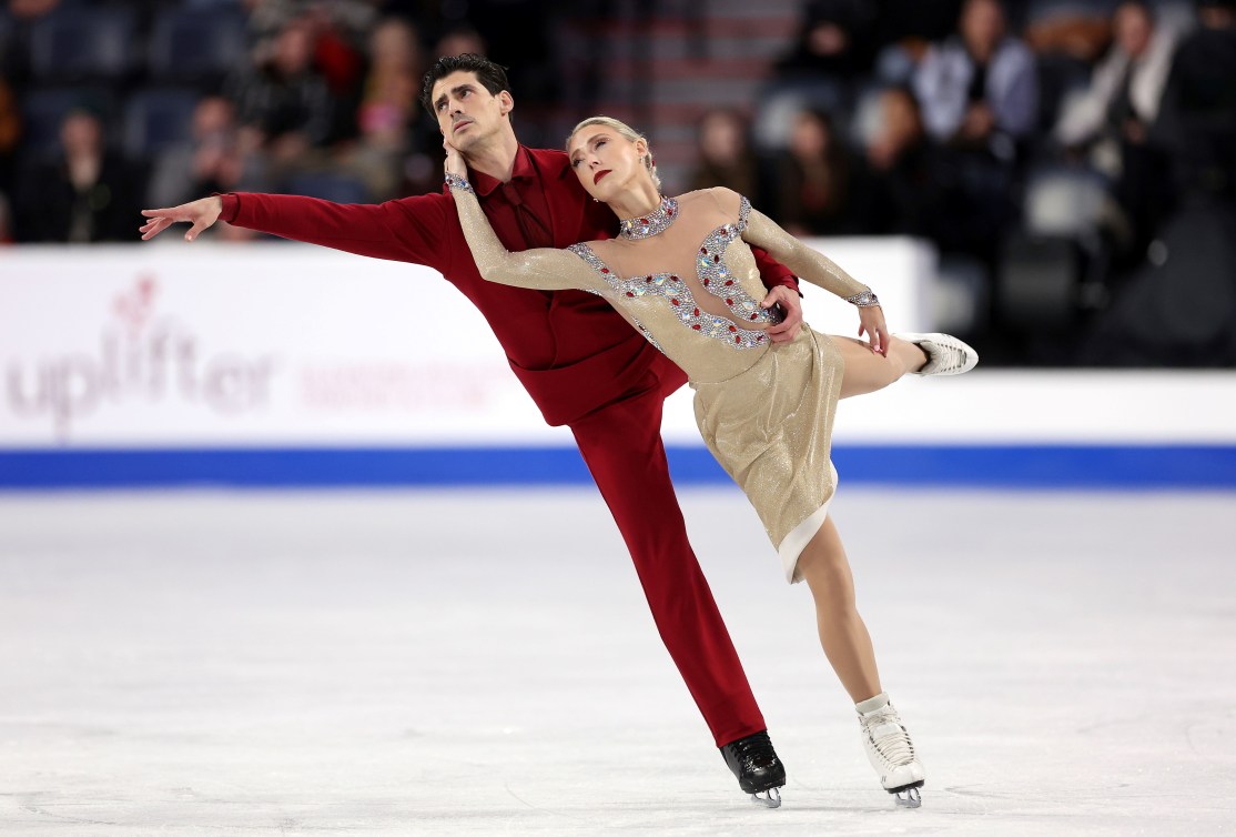 Piper Gilles leans back into Paul Poirier while both of them balance on one leg