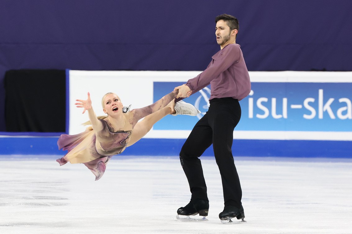 Marjorie Lajoie swings from the arms of partner Zachary Lagha in lavender costumes