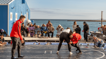 Youth wrestlers practice in front of a waterfront