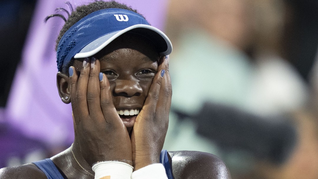 Tennis player reacts with hands on face after winning