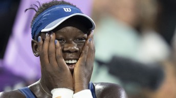 Tennis player reacts with hands on face after winning