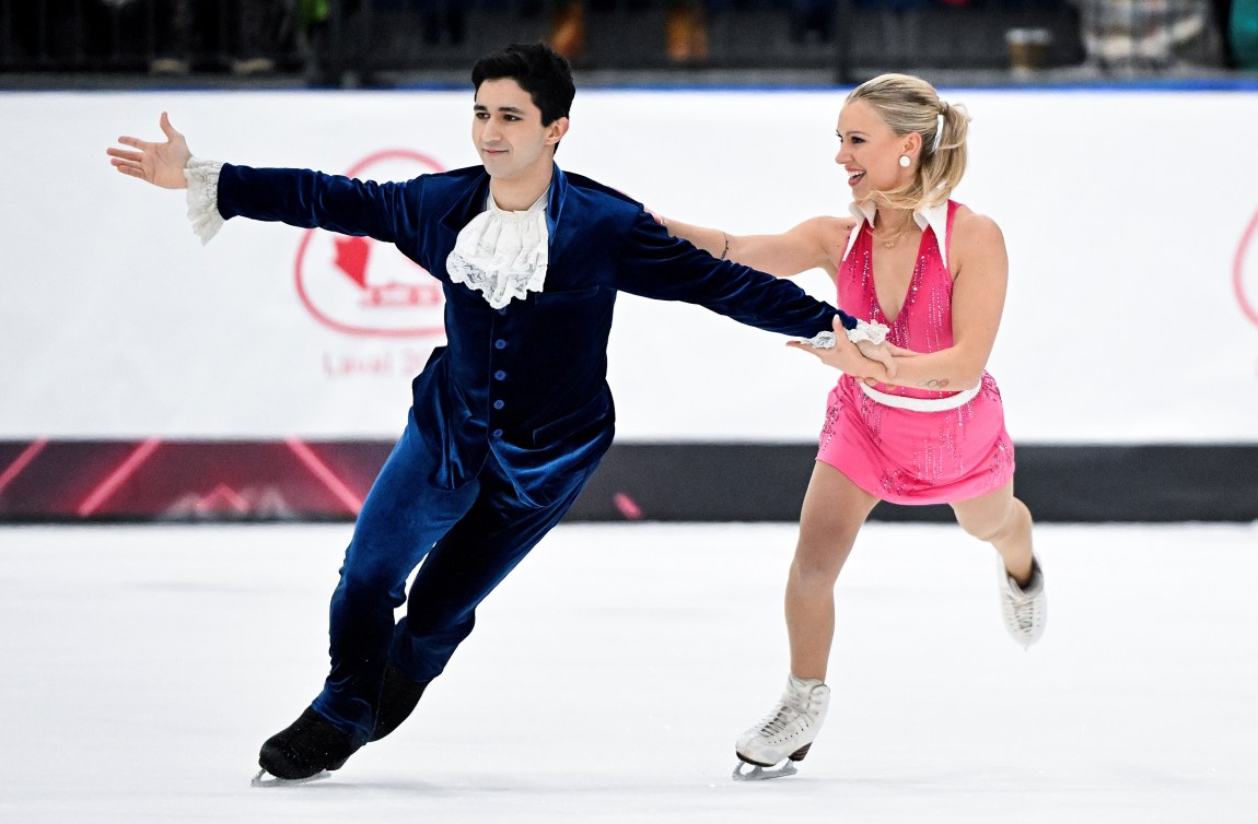 Marjorie Lajoie in a pink halter dress and Zachary Lagha in a navy blue suite with white cravat 