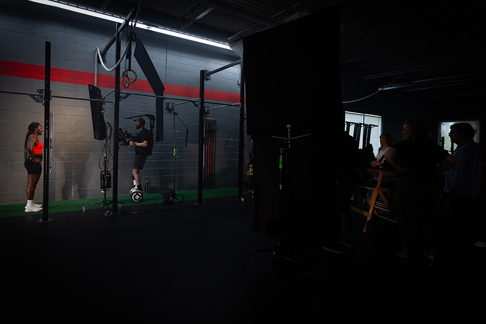 Cynthia Appiah in a gym wearing red, facing a photographer. 