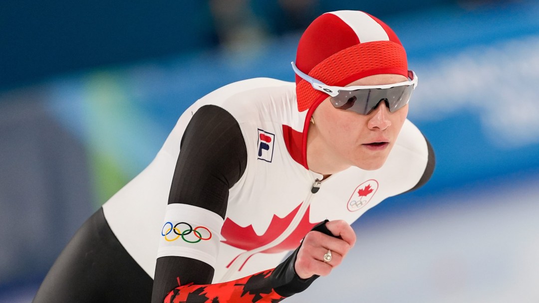 Isabelle Weidemann of Canada, wearing a black and white skinsuit, speeds around the oval during a long track speed skating race at the Milano Cortina 2026 Olympic Winter Games.