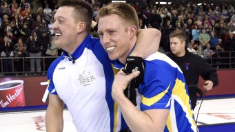 Alberta lead Ben Hebert, left, celebrates with third Marc Kennedy