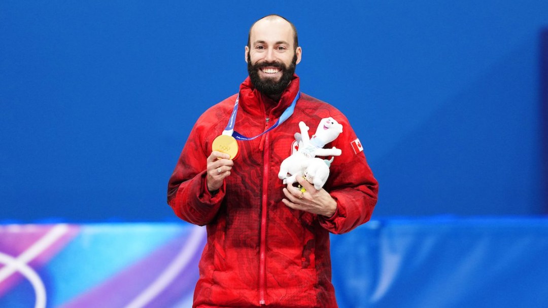 Team Canada's Steven Dubois celebrates winning gold in Short Track Speed Skating men's 500m