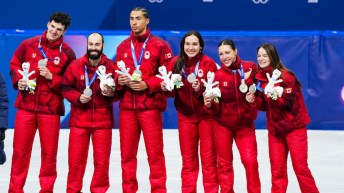 Team Canada short track speed skaters Felix Roussel, Steven Dubois, William Dandjinou, Courtney Sarualt, Florence Brunelle and Kim Boutin celebrate on the podium