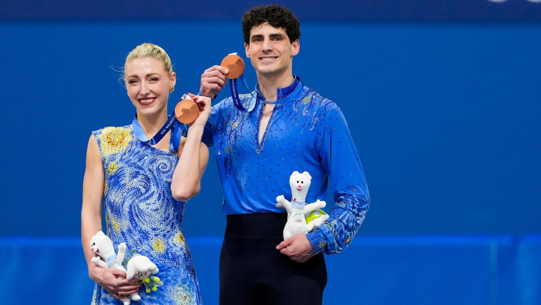 Team Canada’s Piper Gilles and Paul Poirier celebrate on the podium after winning a bronze medal