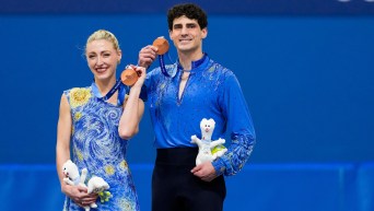 Team Canada’s Piper Gilles and Paul Poirier celebrate on the podium after winning a bronze medal