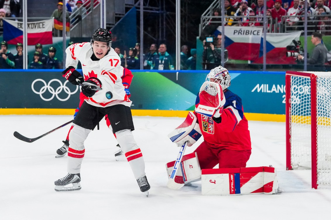 Macklin Celebrini tips a puck before scoring