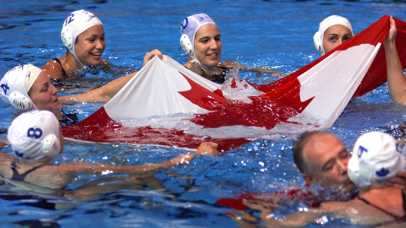 L'équipe féminine porte le drapeau dans la piscine