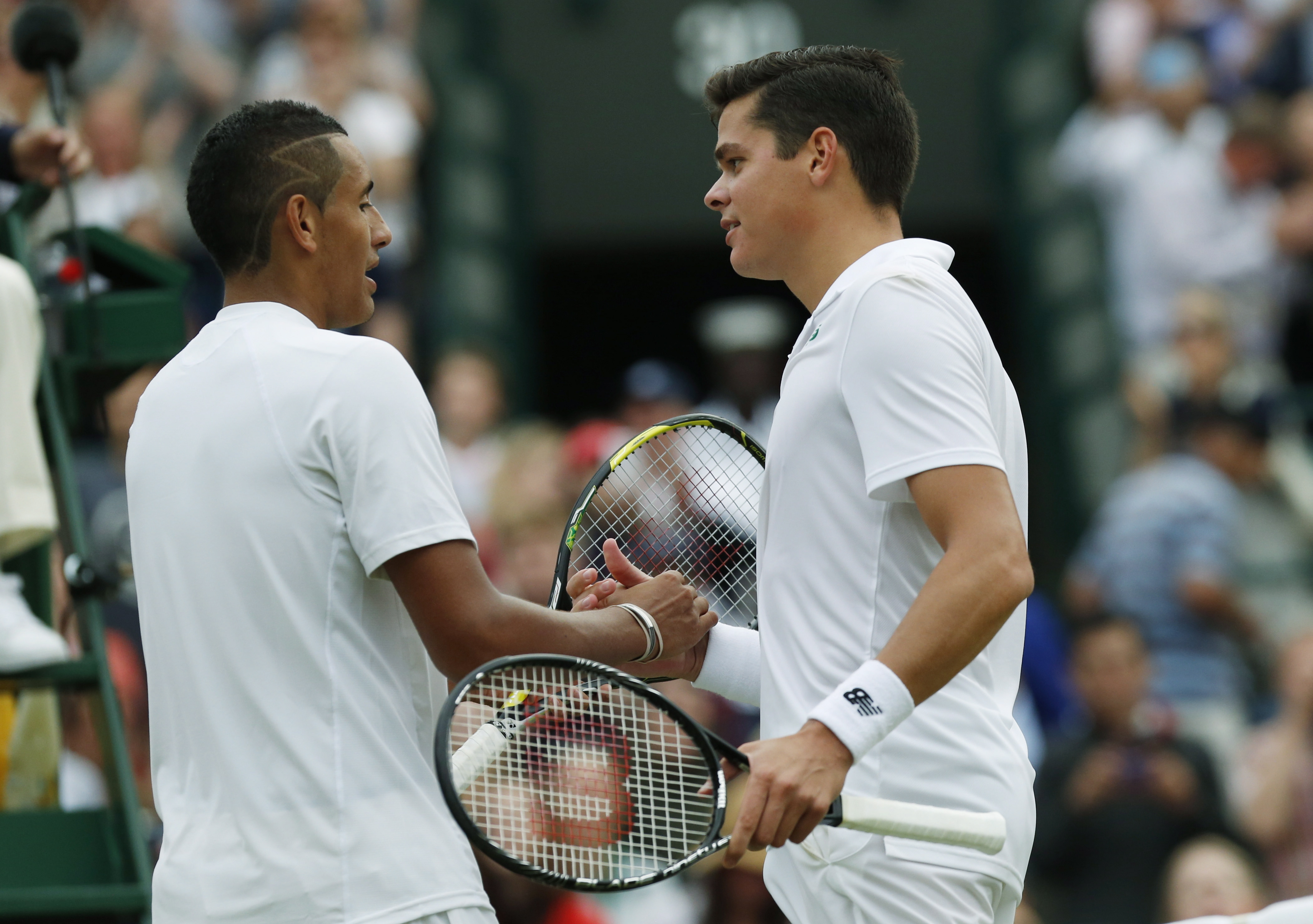 Milos Raonic of Canada, right, shakes hands with Nick Kyrgios of Australia after defeating him in their men's singles quarterfinal match at the All England Lawn Tennis Championships in Wimbledon, London, Wednesday, July 2, 2014. (AP Photo/Ben Curtis)
