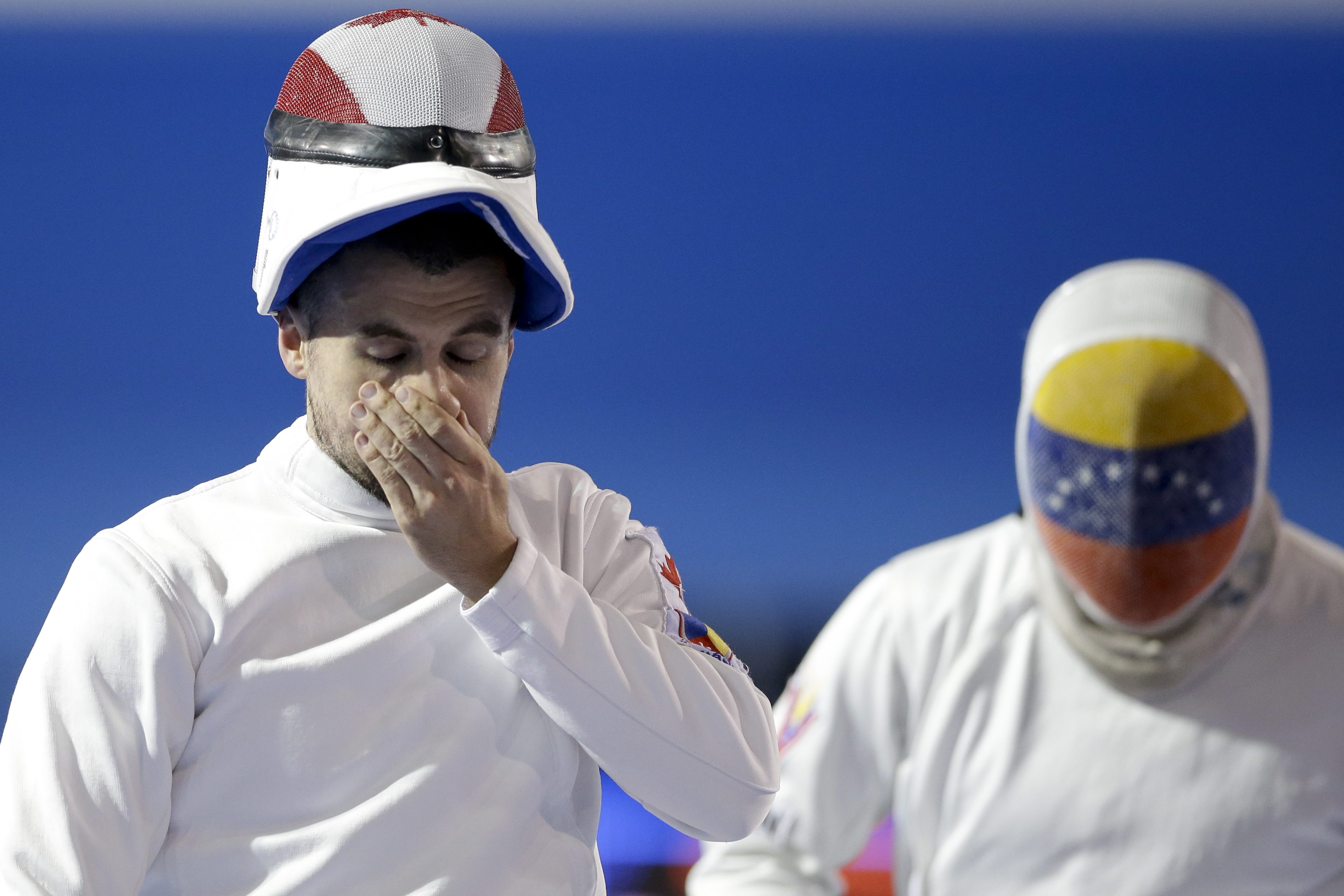 Canada's Maxime Brinck-Croteau, left, reacts during his epee bout against Venezuela's Ruben Limardo, right, in fencing competition in the Pan Am Games in Toronto Tuesday, July 21, 2015. Limardo won, 15-0. (AP Photo/Gregory Bull)