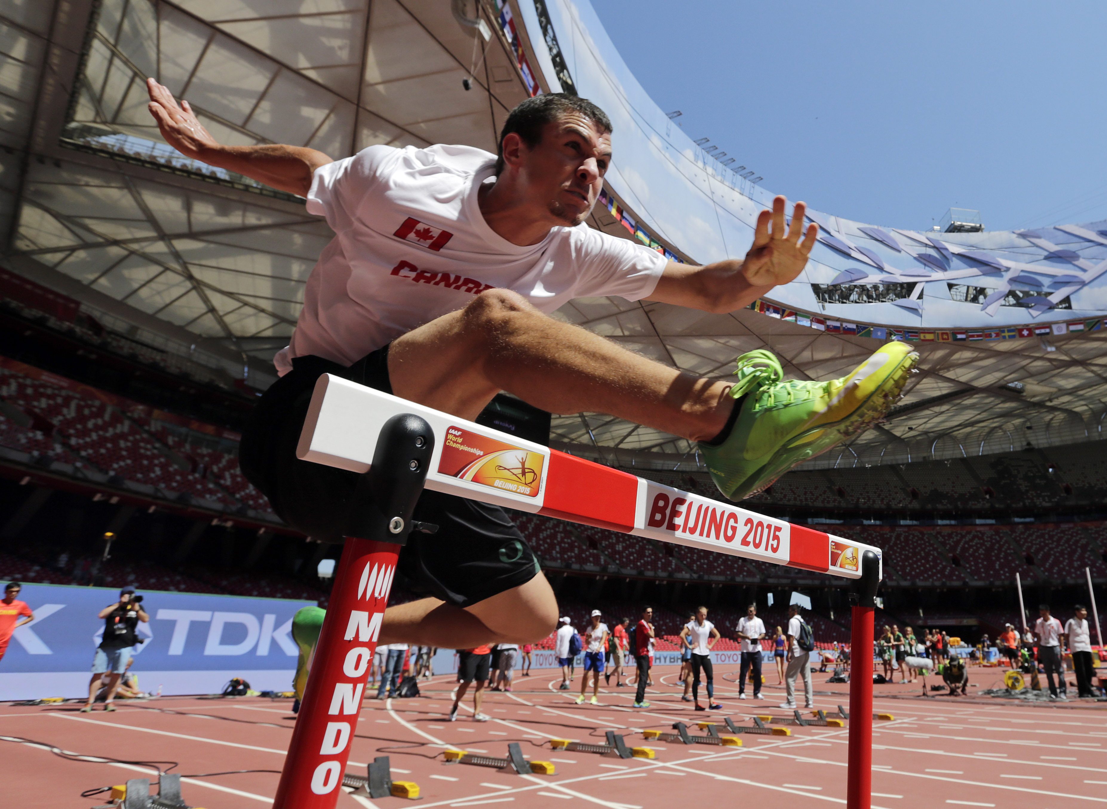 Canada's Johnathan Cabral clears a hurdle during a training session before the World Athletic Championships at the Bird's Nest stadium in Beijing, Friday, Aug. 21, 2015. (AP Photo/Andy Wong)