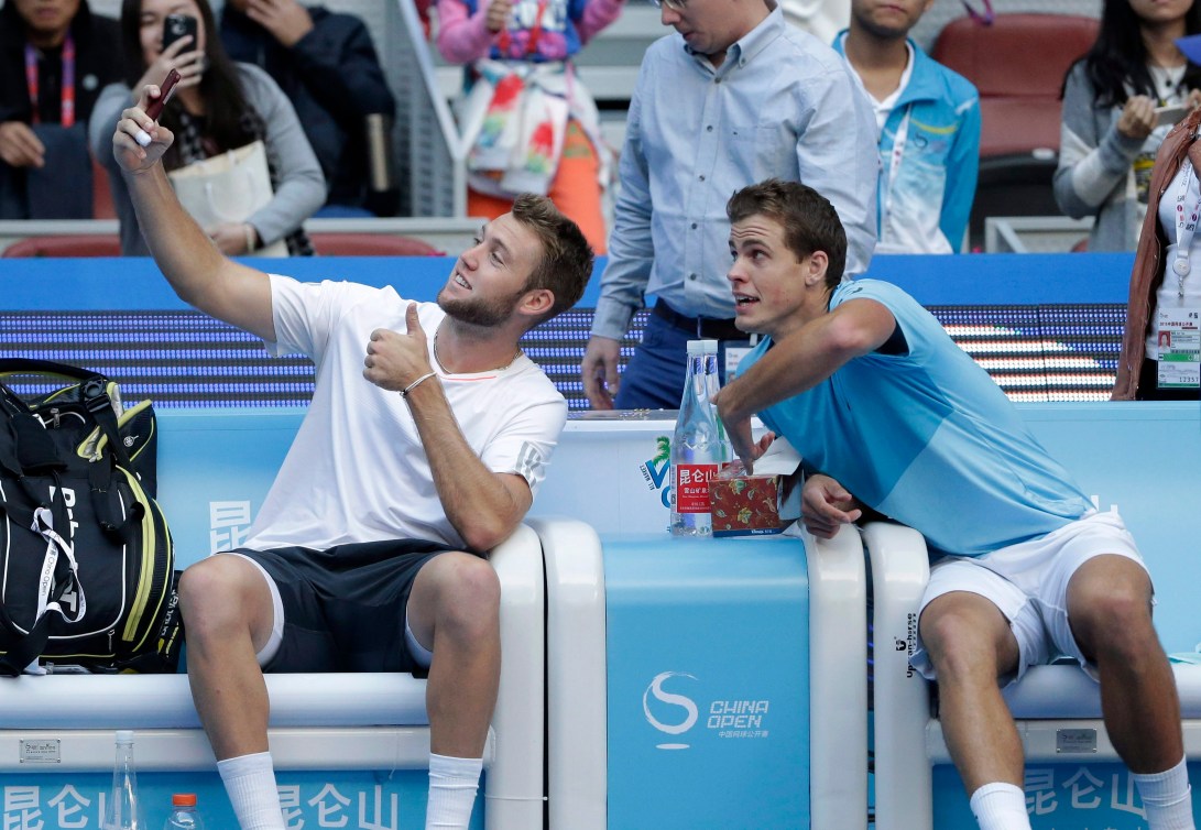 Jack Sock et Vasek Pospisil prennent un selfie après avoir défait Daniel Nestor et Edouard Roger-Vasselin en finale du tournoi China Open à Beijing, le 11 octobre 2015. (AP Photo/Andy Wong)