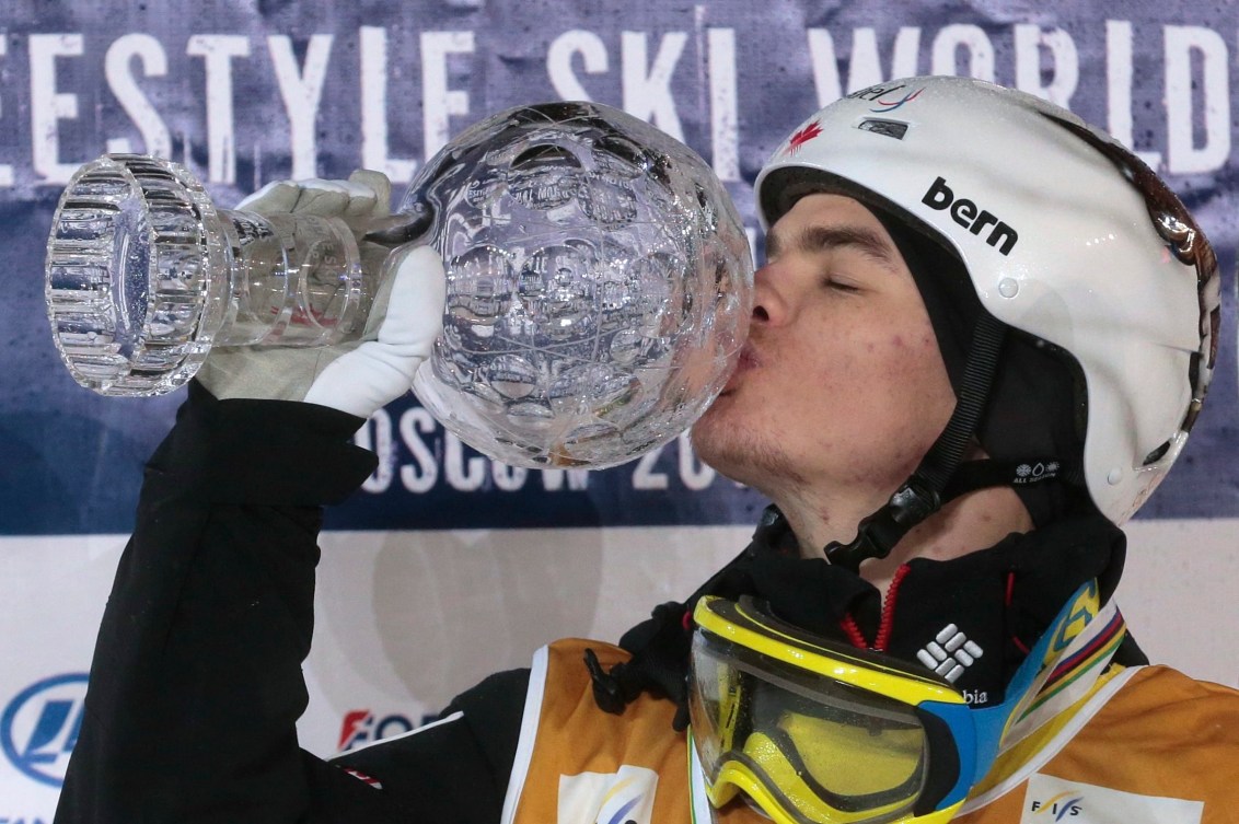 Mikaël Kingsbury embrasse le Globe de cristal qui le proclame champion des bosses pour la saison 2015-2016, le 5 mars 2016. (AP Photo/Ivan Sekretarev)