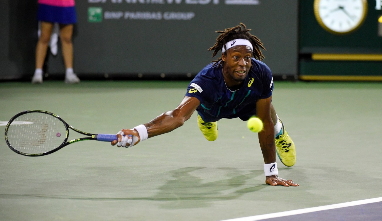 le Francçais Gaël Monfils plonge pour tenter de frapper une balle renvoyée par le Canadien Milos Raonic en quarts de finale du tournoi d'indian Wells, le 17 mars 2016. (AP Photo/Mark J. Terrill)